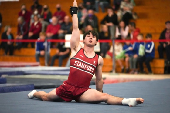 Zach Martin holding a split with one arm raised during a floor routine
