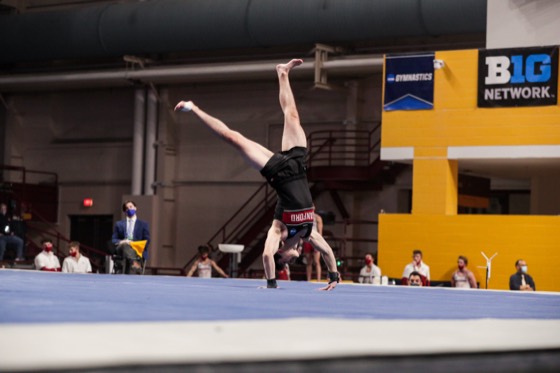 Zach Martin in a lunge with his arms extended during a floor routine
